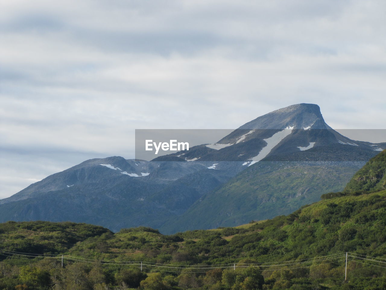 Scenic view of mountains against cloudy sky