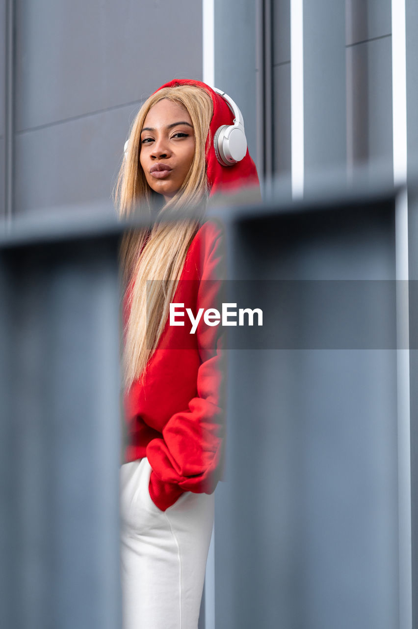 Cheerful african american woman with long blonde hair wearing sportswear and wearing headphones