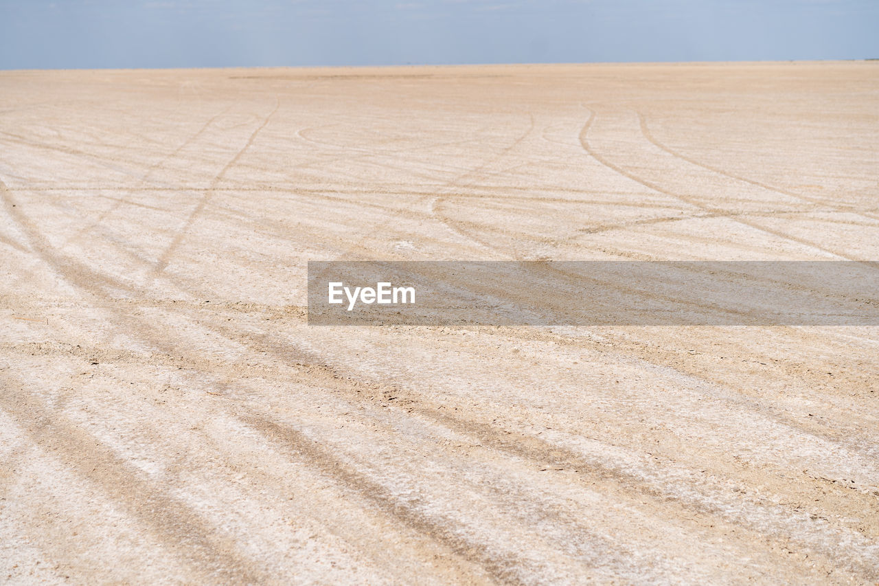 HIGH ANGLE VIEW OF TIRE TRACKS ON FIELD