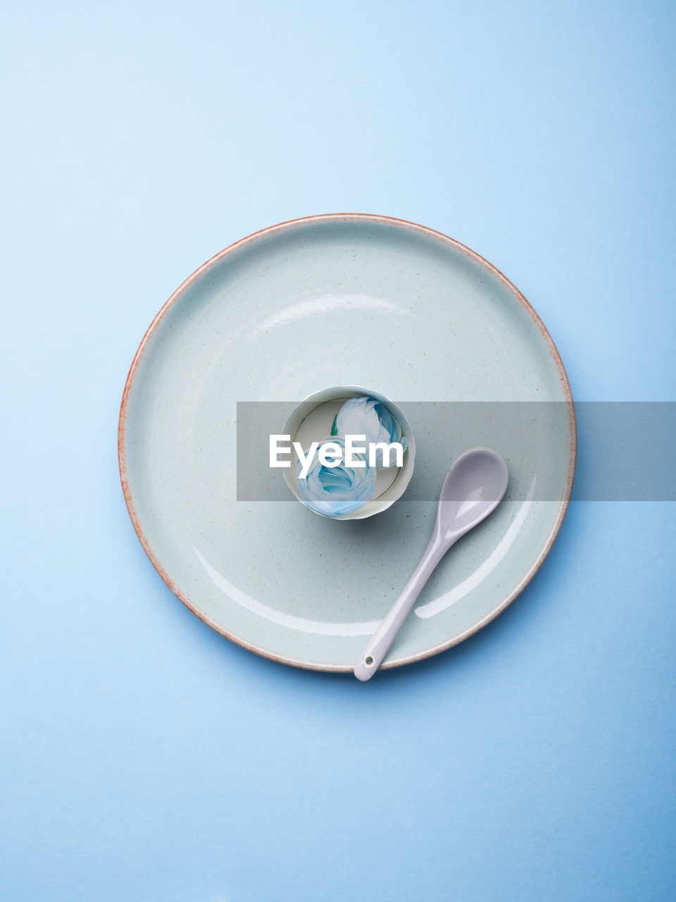 Blue pastel ceramic dish with flowers and spoon. abstract food, tableware crockery, table setting 