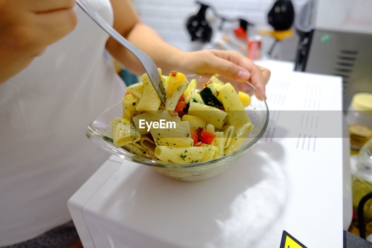 Midsection of woman holding pasta