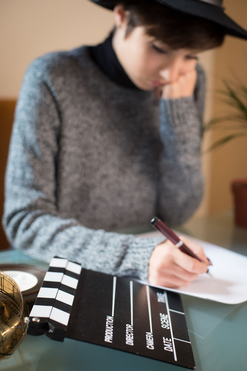 Woman writing on paper at table