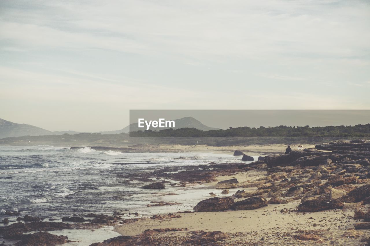 SCENIC VIEW OF SEA BY MOUNTAINS AGAINST SKY