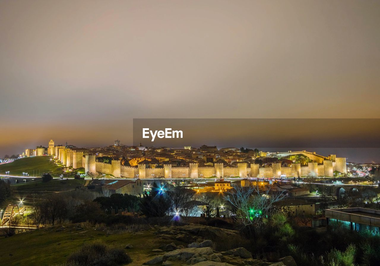 HIGH ANGLE VIEW OF ILLUMINATED BUILDINGS AGAINST SKY