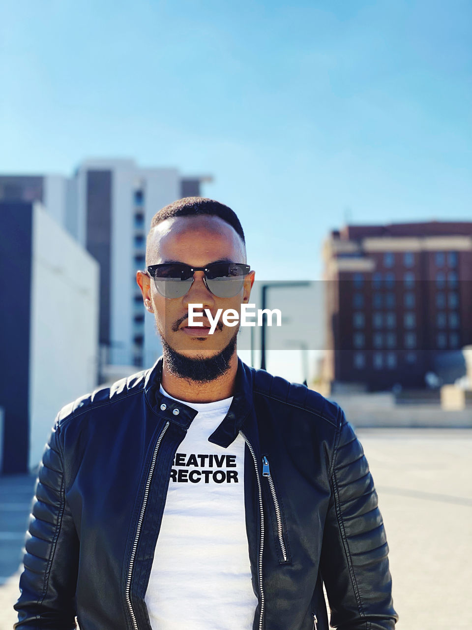 PORTRAIT OF YOUNG MAN WEARING SUNGLASSES AGAINST SKY