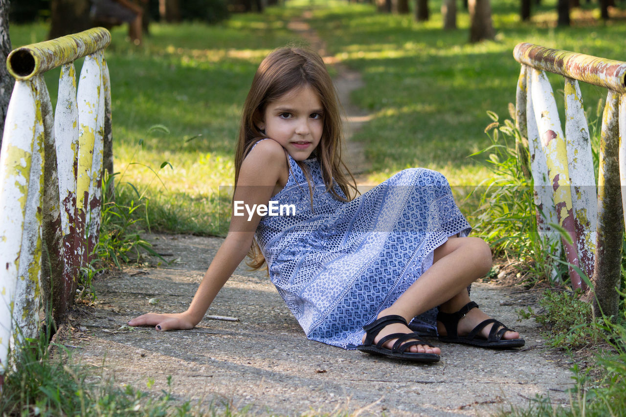 Portrait of girl sitting at park outdoors