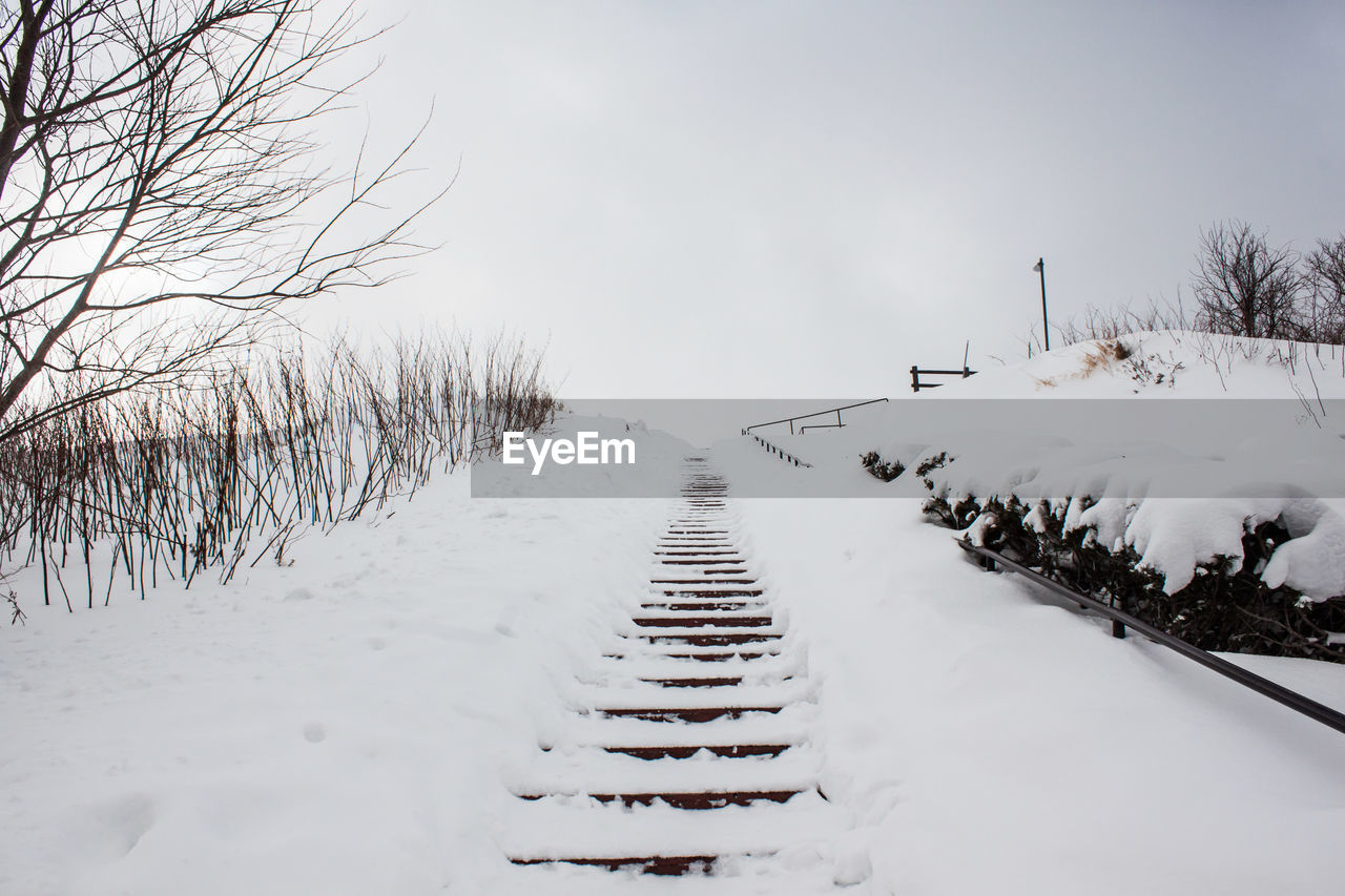 Scenic view of snow covered field against sky