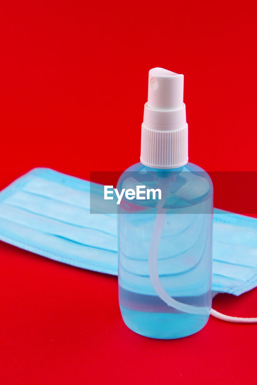 Close-up of bottle on table against red background