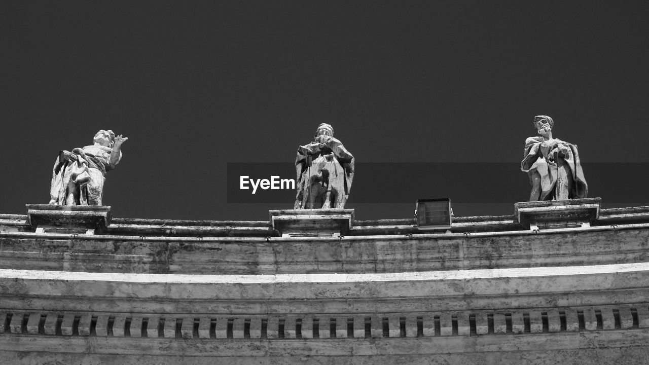 Low angle view of statue on wall against sky