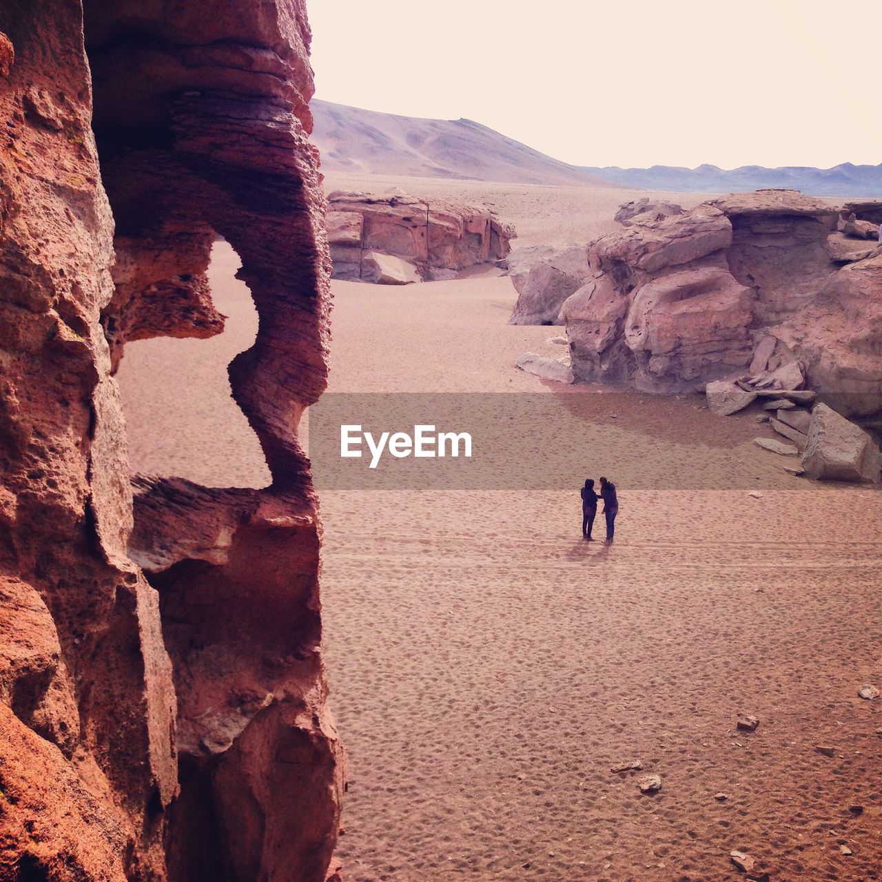 Rear view of people walking on rocky mountain