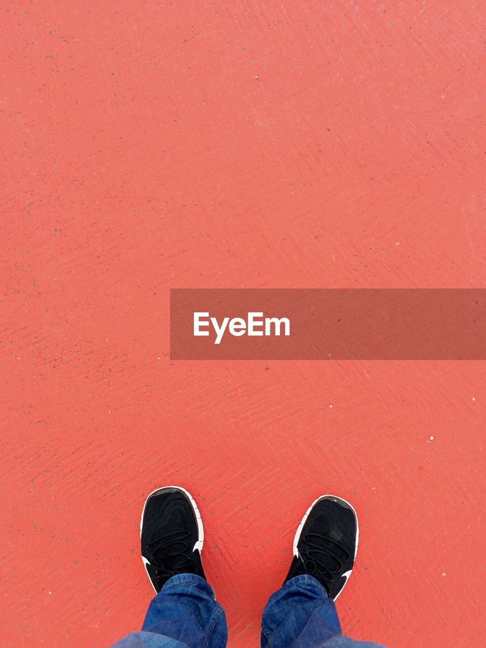 Low section of man standing on orange floor