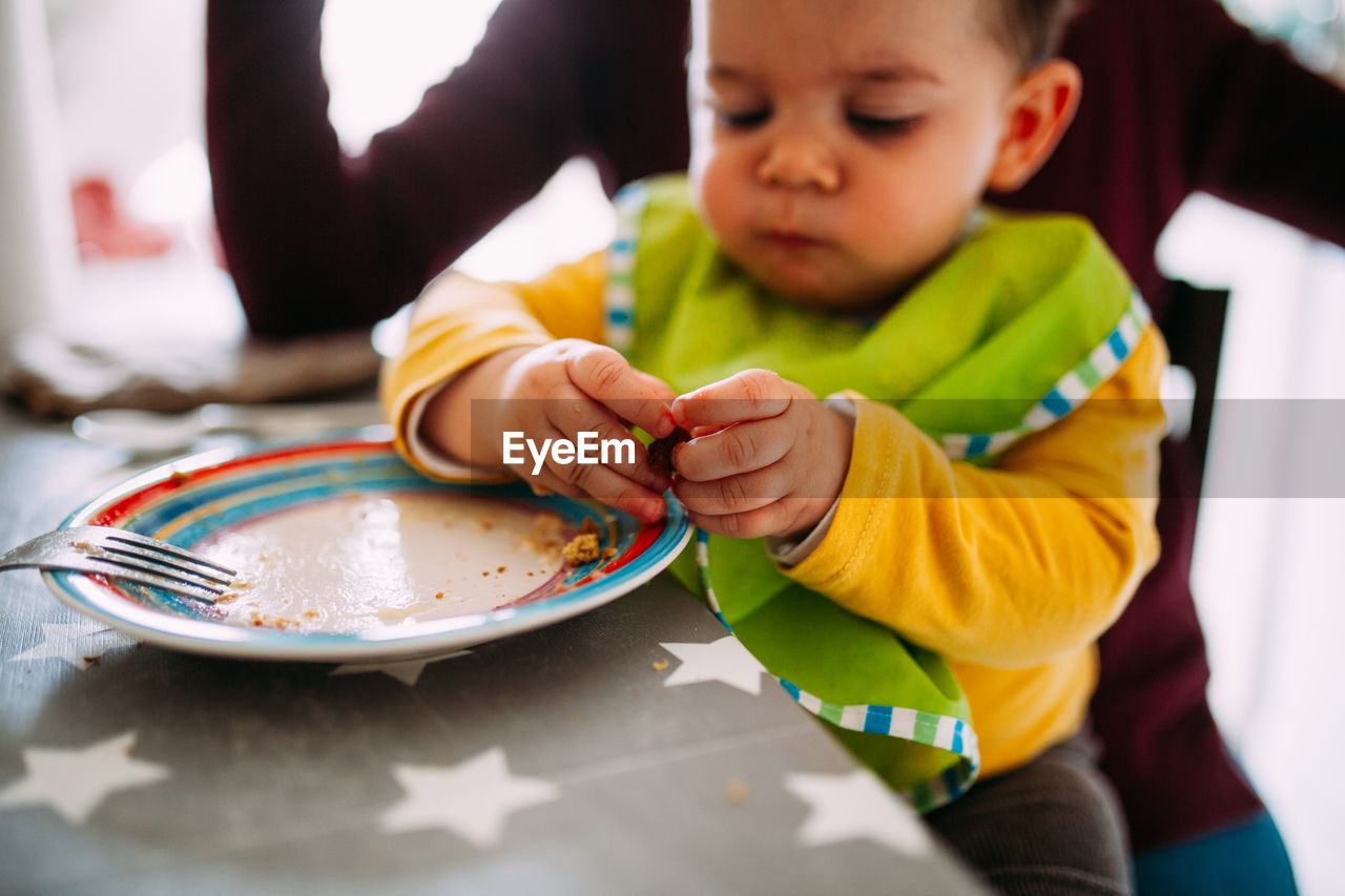 MIDSECTION OF BOY HOLDING TABLE