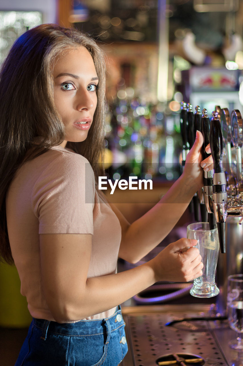 CLOSE-UP OF A YOUNG WOMAN WITH DRINK IN RESTAURANT