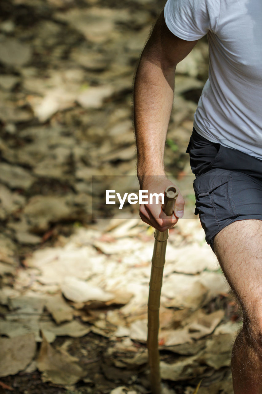 Midsection of man hiking in forest