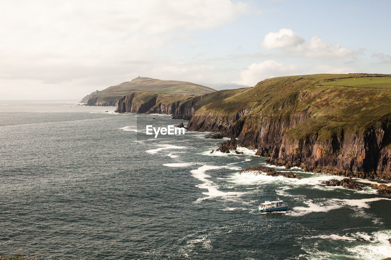 Scenic view of cliffs and sea against sky