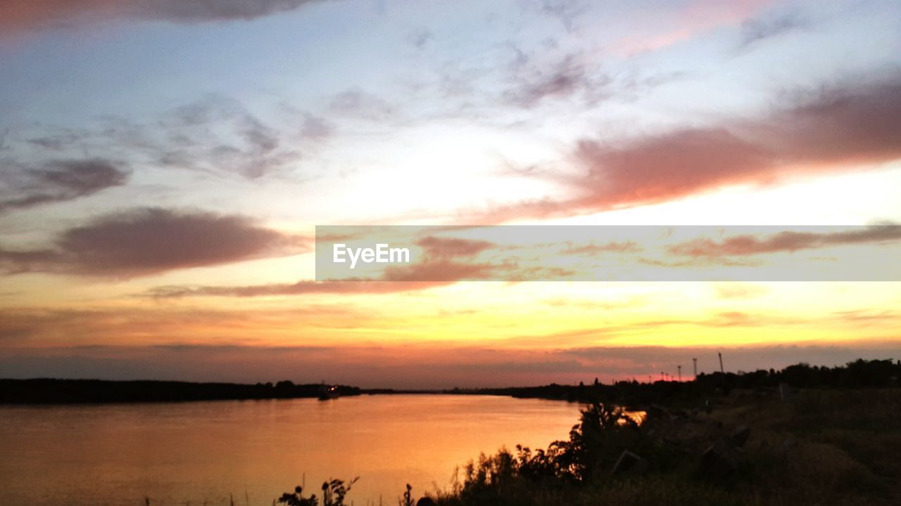 SCENIC VIEW OF LAKE AGAINST SKY DURING SUNSET