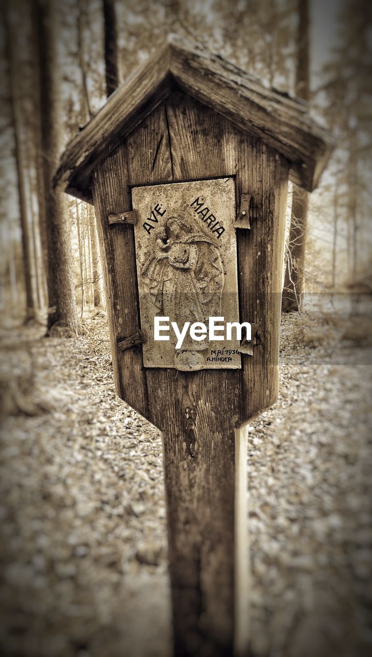 CLOSE-UP OF WOODEN POST ON STONE WALL