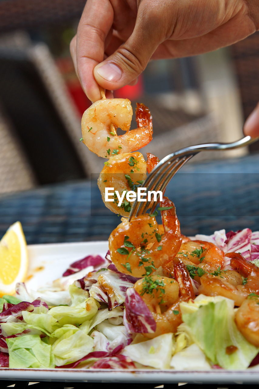 CLOSE-UP OF HAND HOLDING FOOD