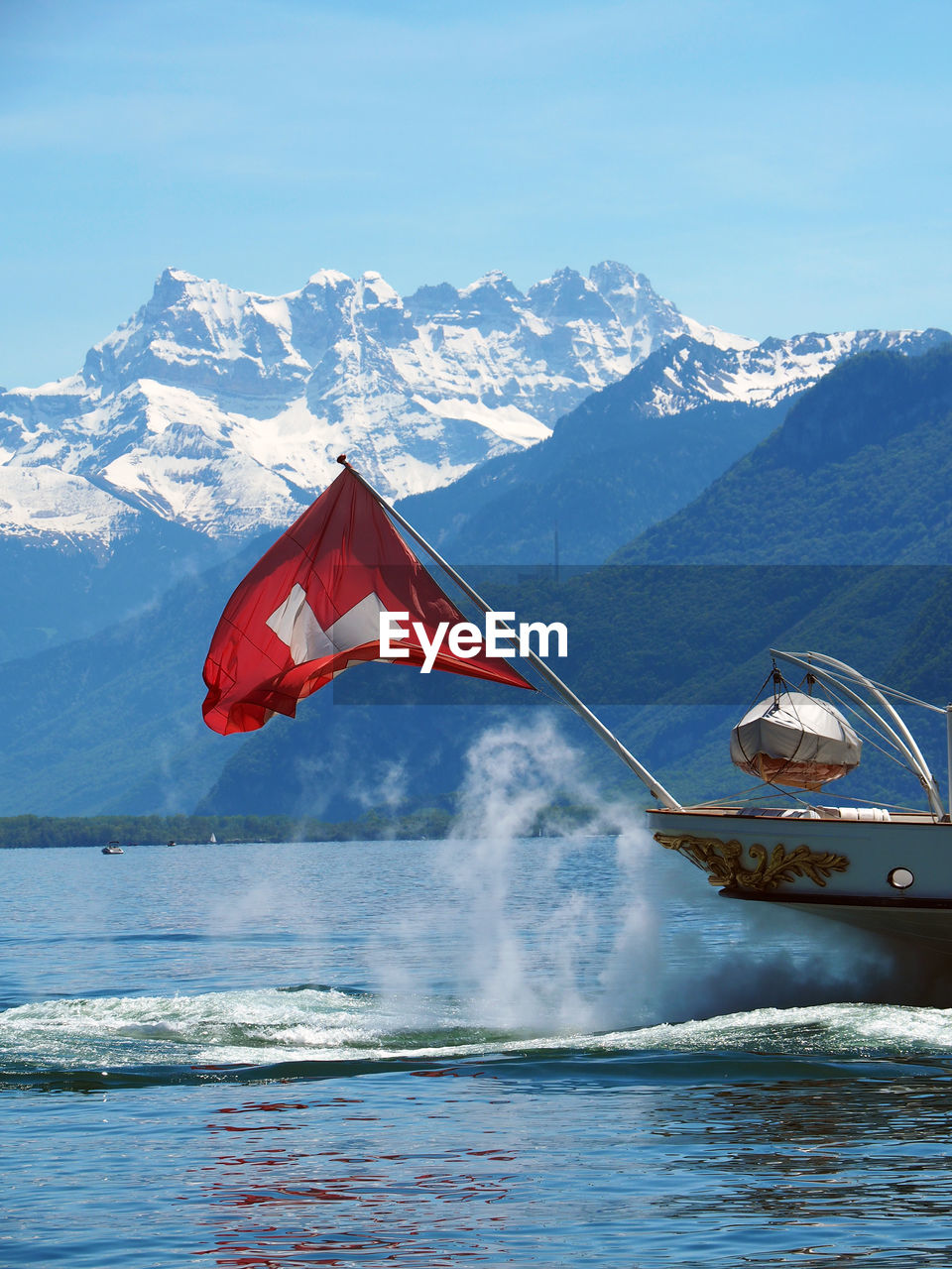 Swiss flag on passenger craft against snowcapped mountain