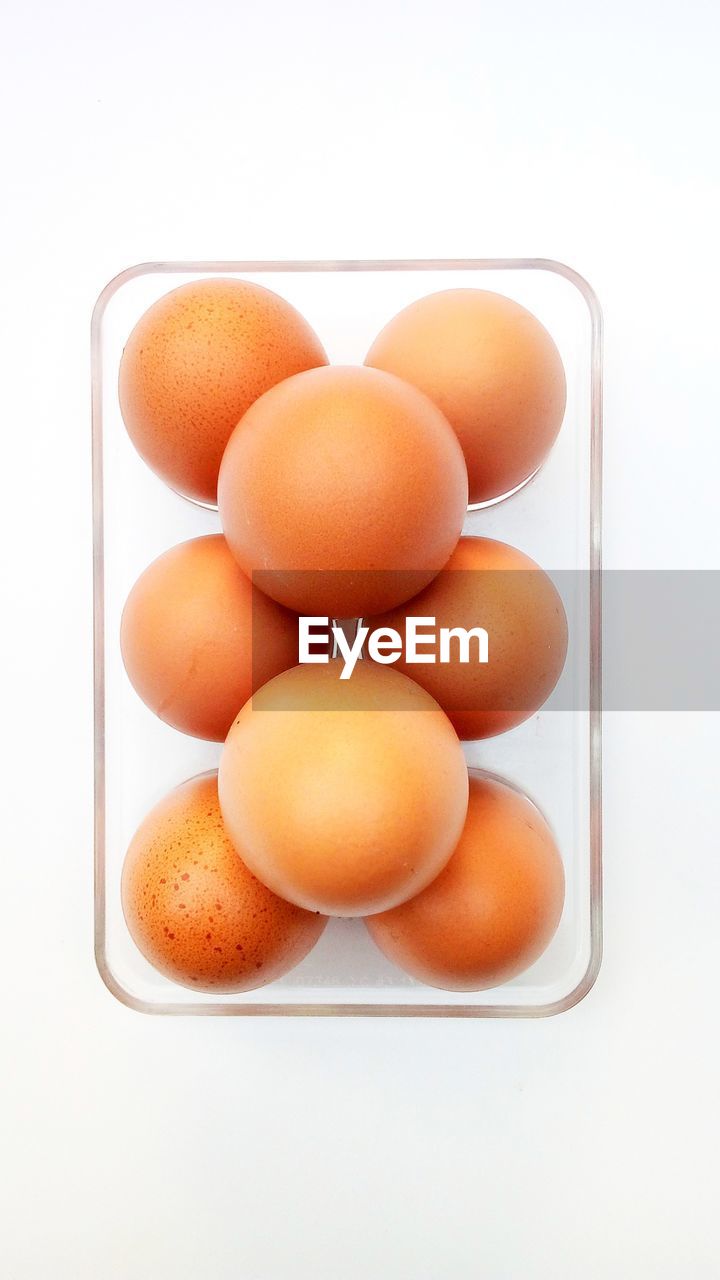 HIGH ANGLE VIEW OF EGGS IN WHITE CONTAINER