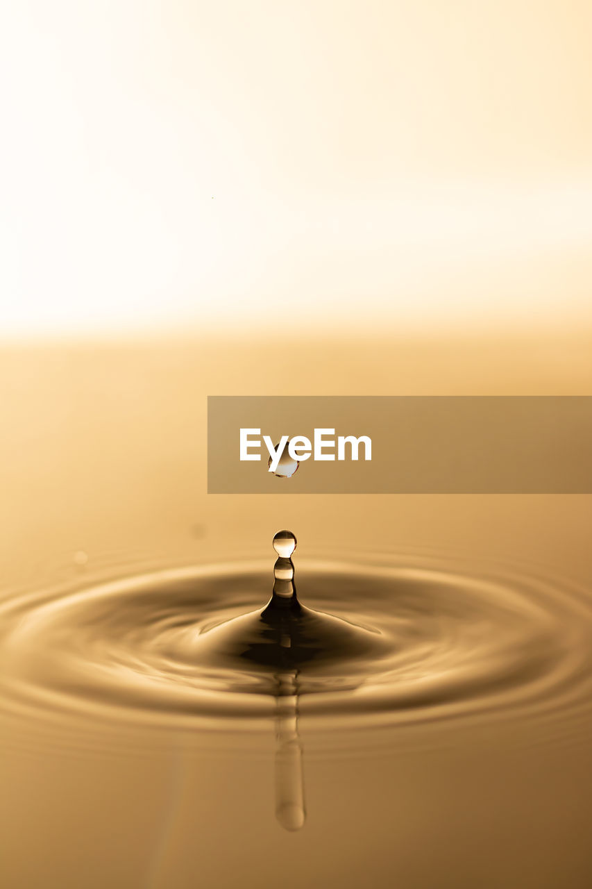 close-up of water drop against sky during sunset