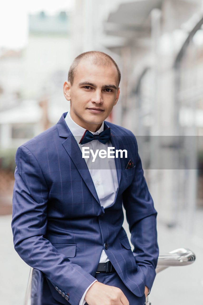 Portrait of businessman standing in city