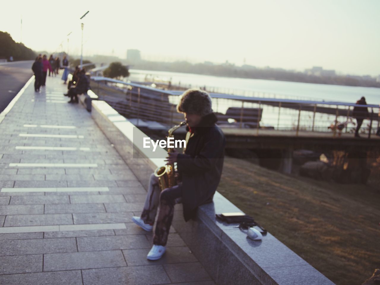 MAN SITTING ON BENCH IN CITY