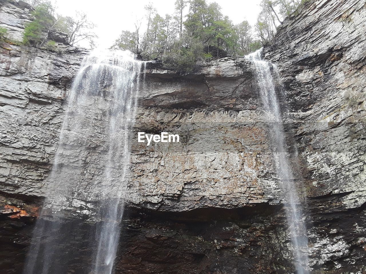 LOW ANGLE VIEW OF WATERFALL ON CLIFF