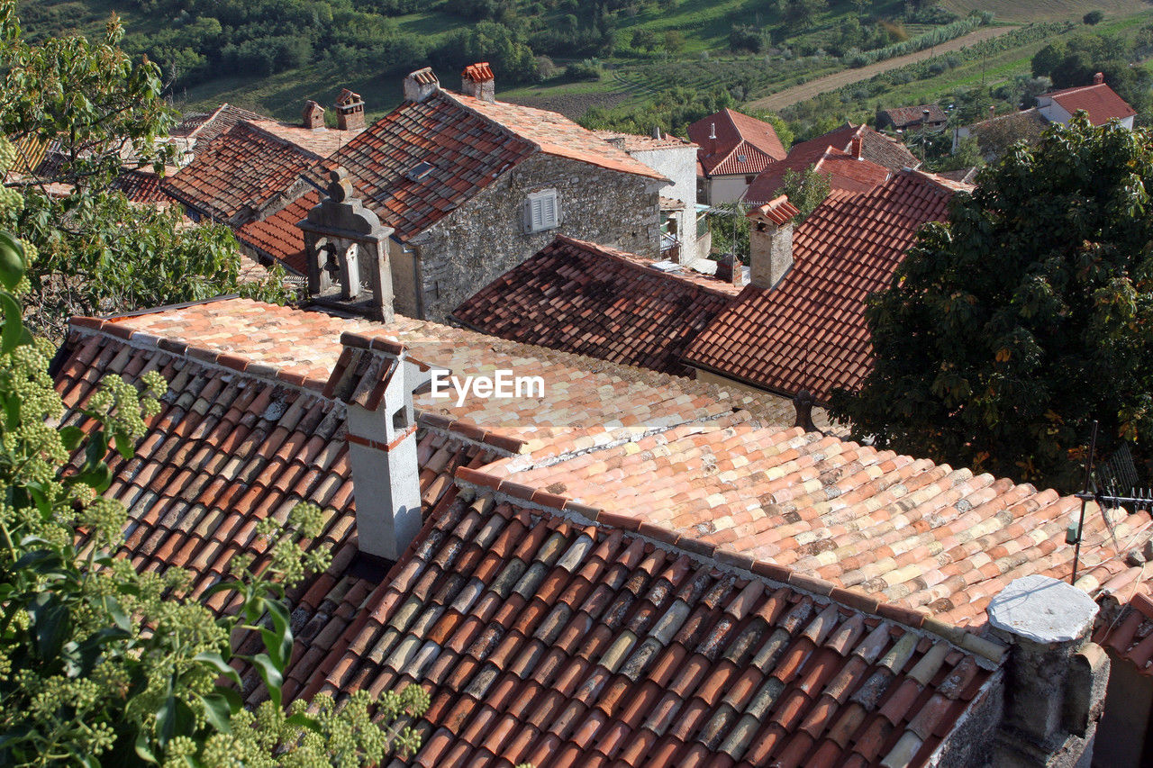 roof, architecture, roof tile, high angle view, built structure, building exterior, building, house, nature, residential district, tree, plant, day, outdoors, no people, city, village, outdoor structure, sunlight, residential area