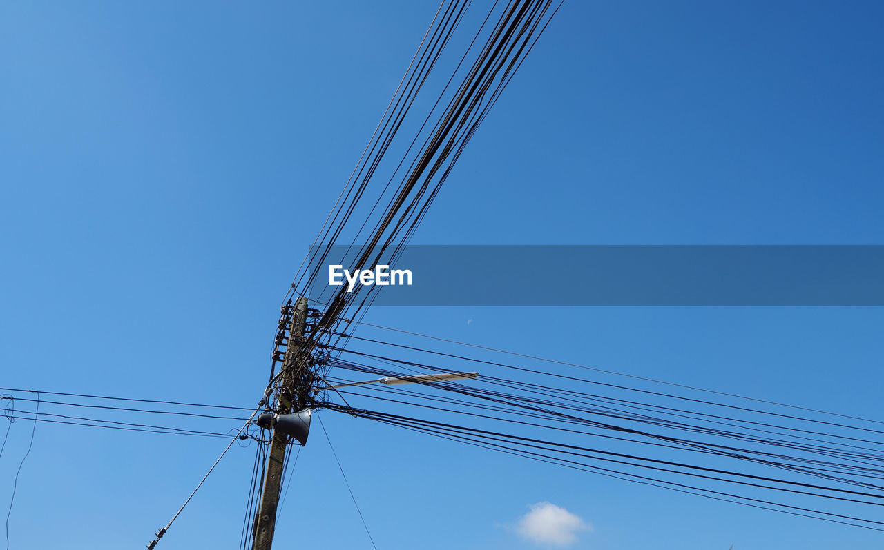 Low angle view of cables against blue sky