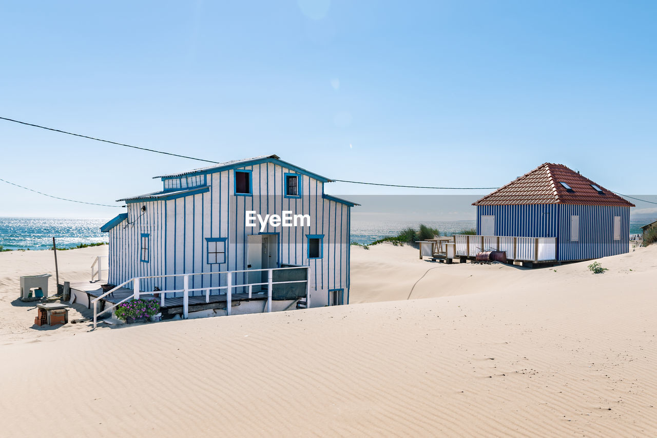 BEACH HUT AGAINST CLEAR SKY