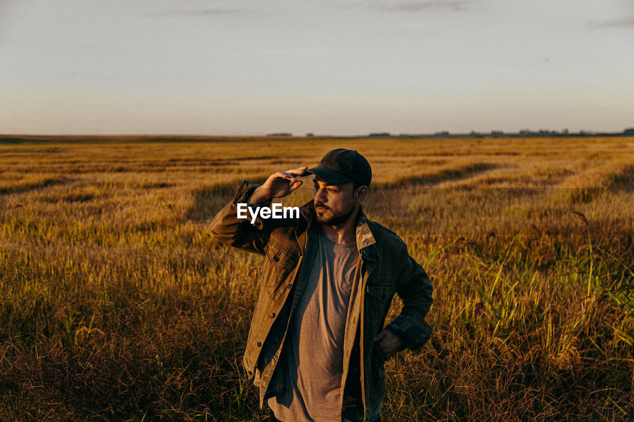 Portrait of a man in a field at sunset