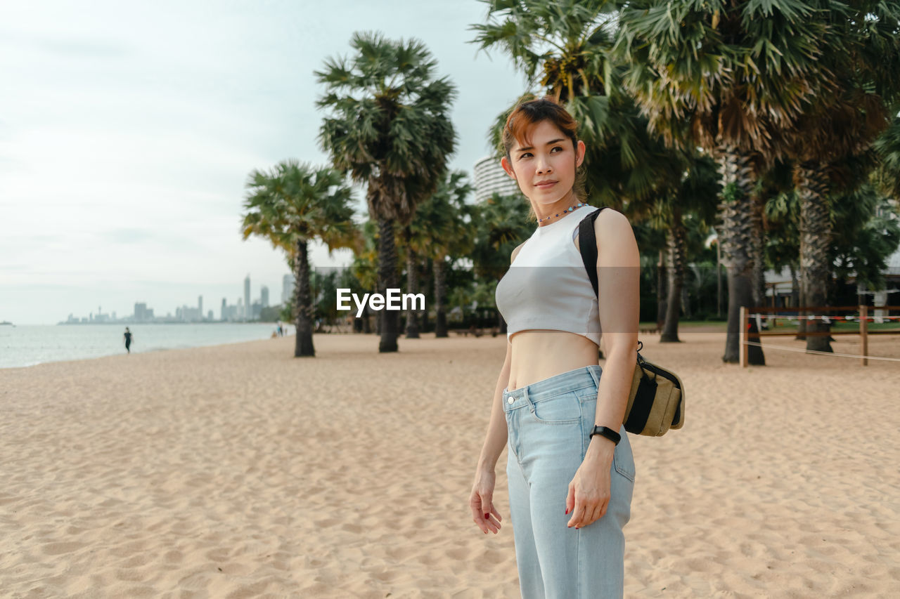 Portrait of young woman standing on beach