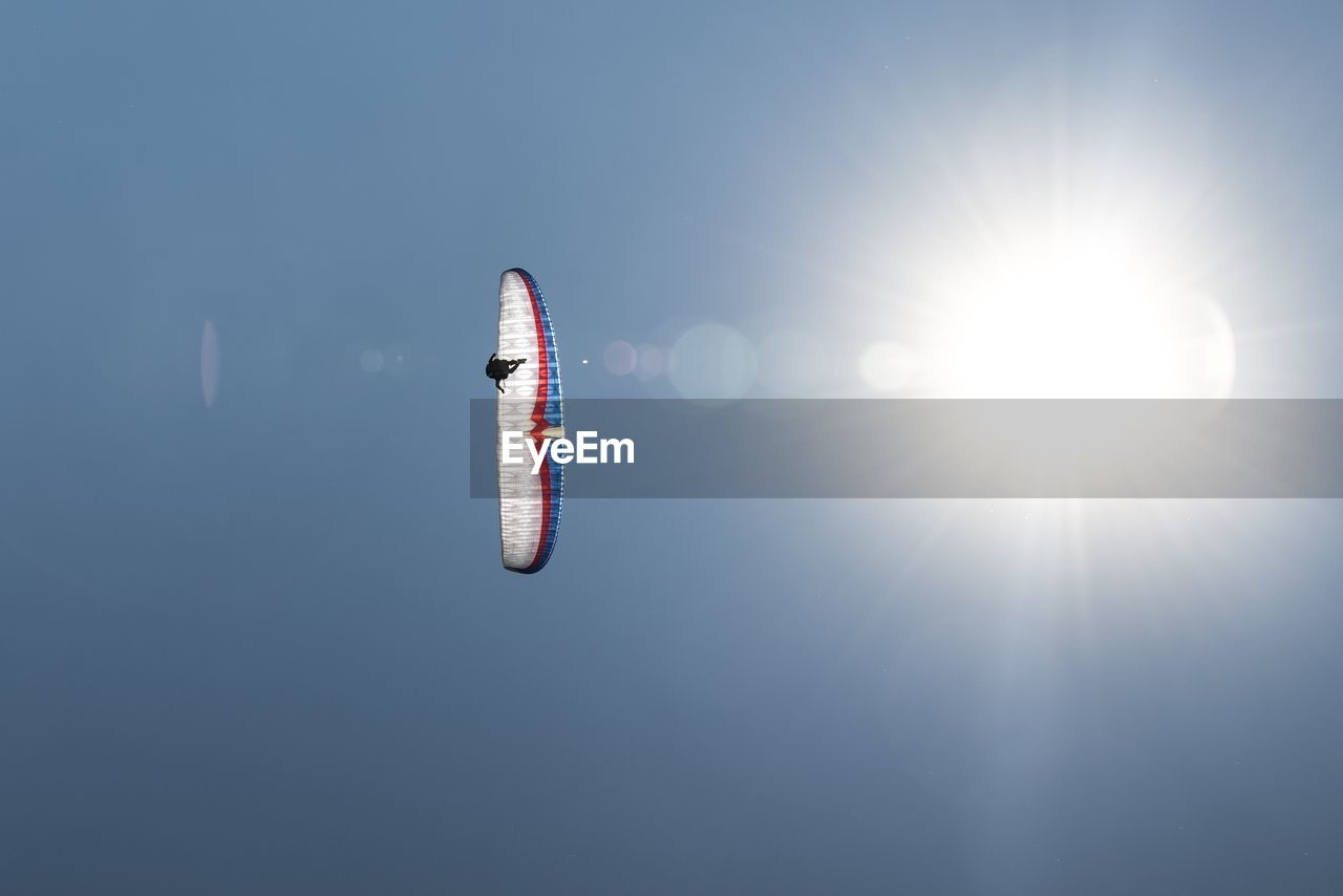 Low angle view of person paragliding against sky