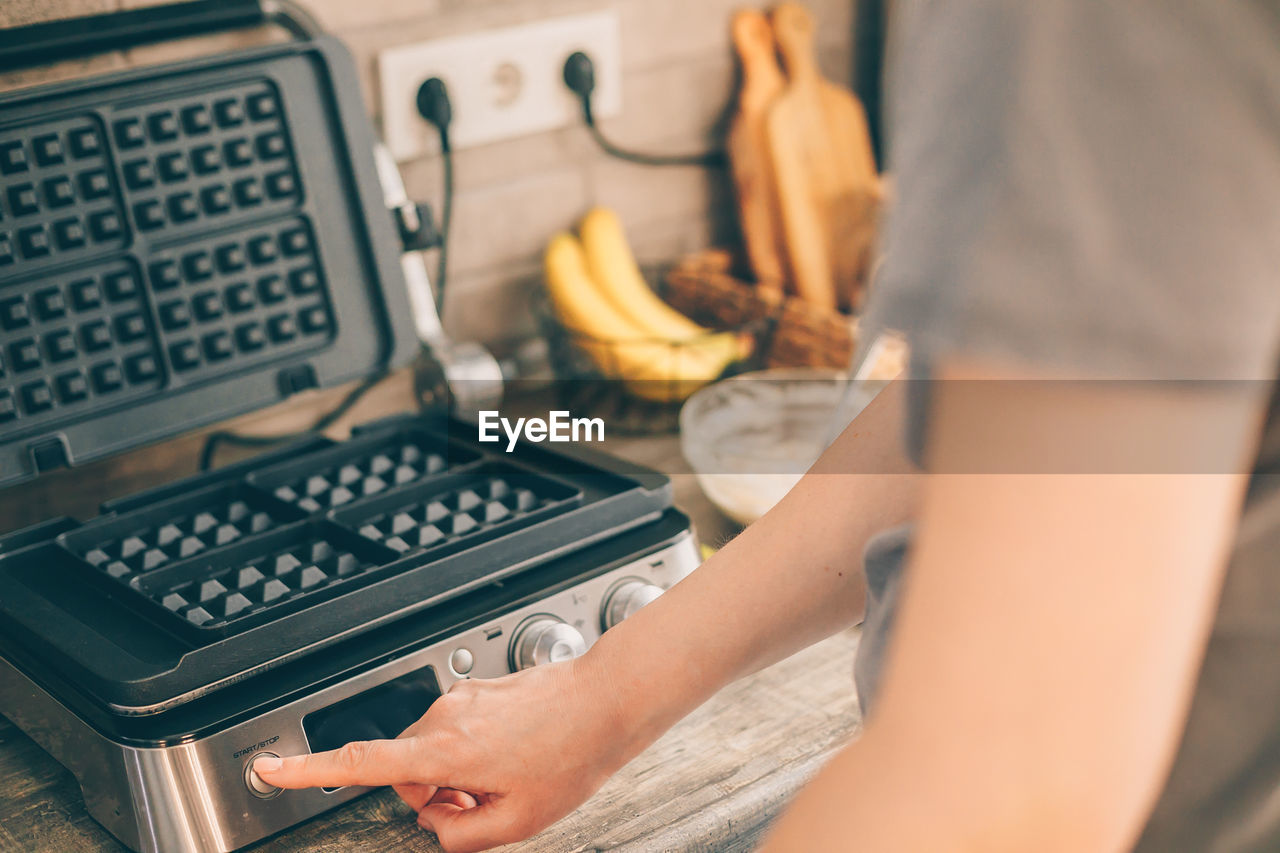 Midsection of woman using cooking machine