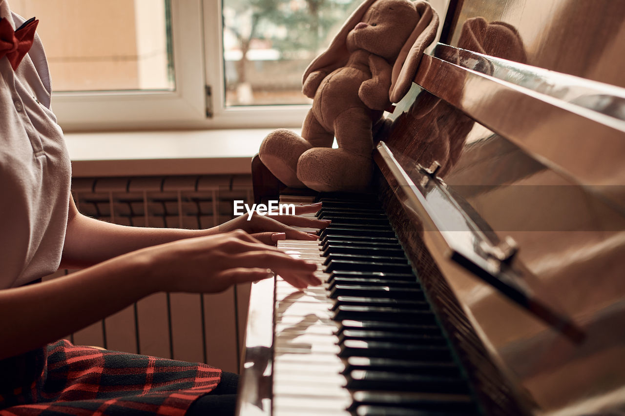 Asian high school student sitting at the piano