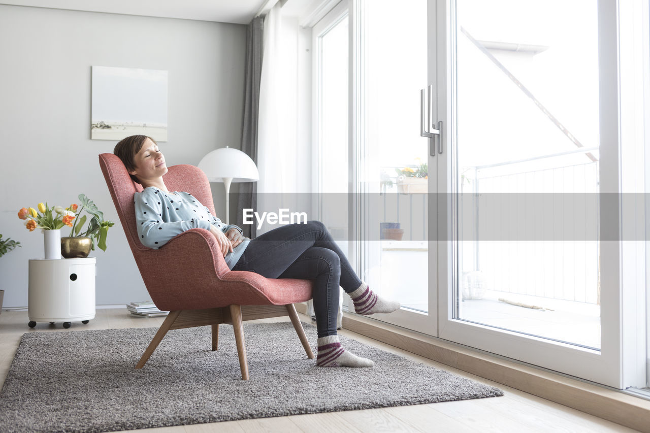 Woman relaxing on armchair at home