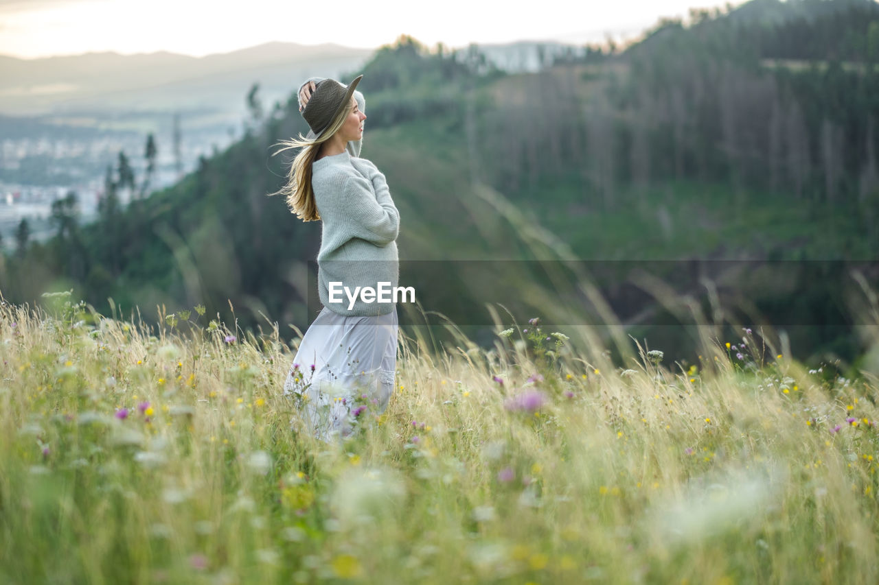 Portrait happy woman enjoying stay on green grass. fresh air, travel, fall, journey, trip, lifestyle