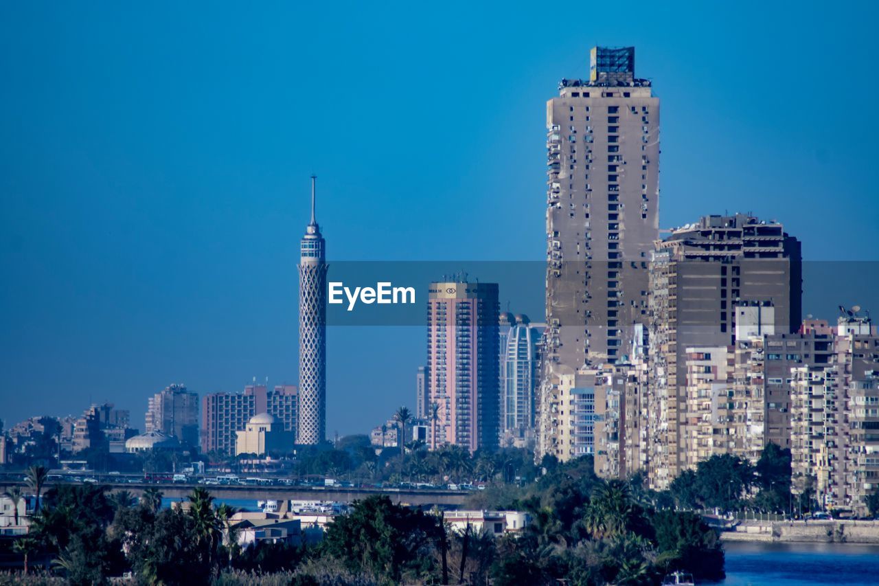 Skyscrapers in city against clear blue sky