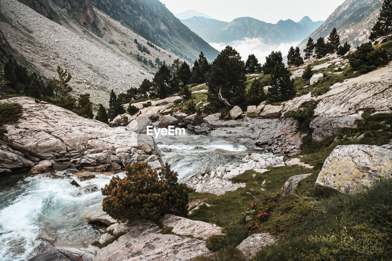 Scenic view of river amidst mountains against sky