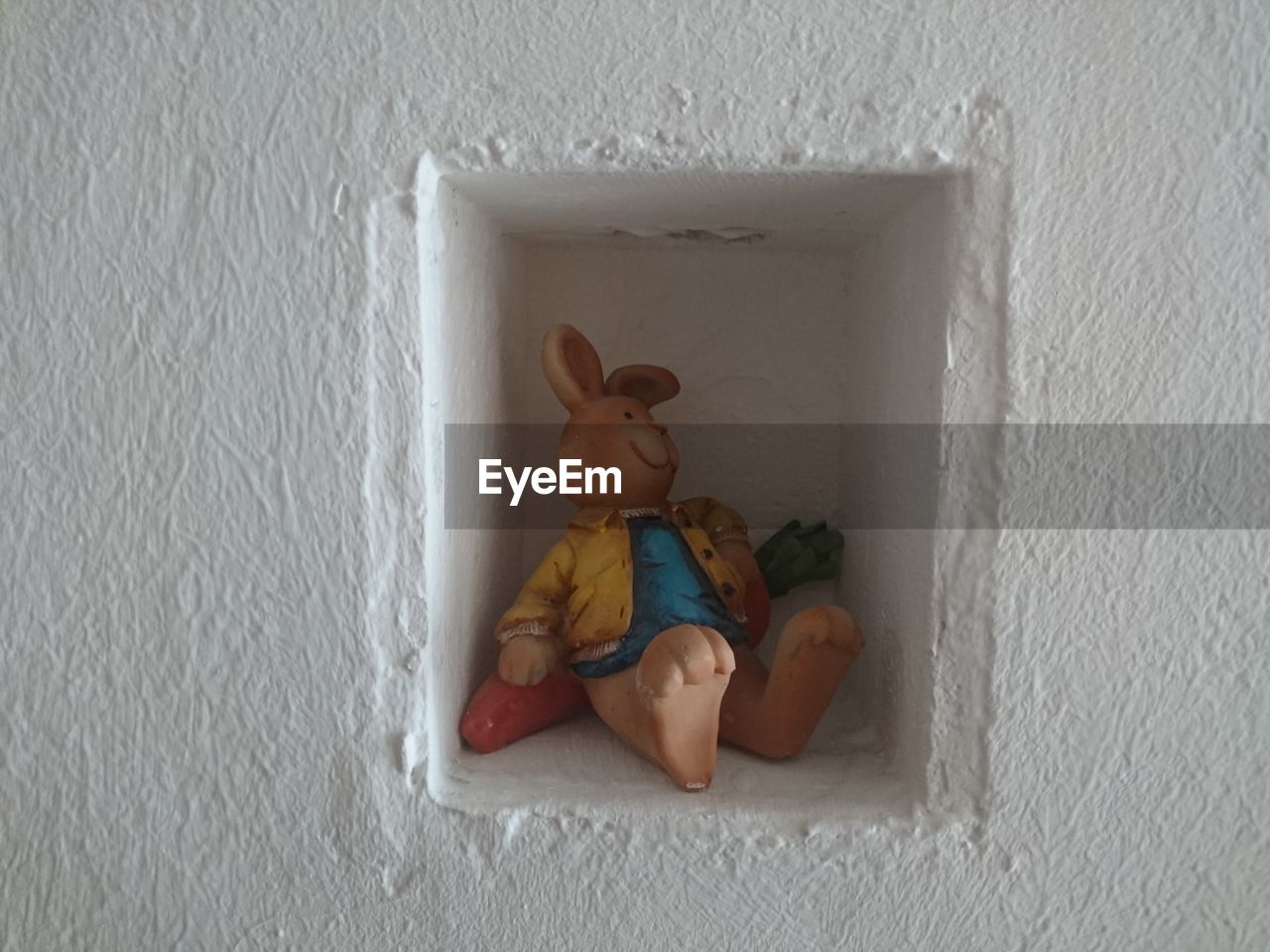 Toy in niche on white wall