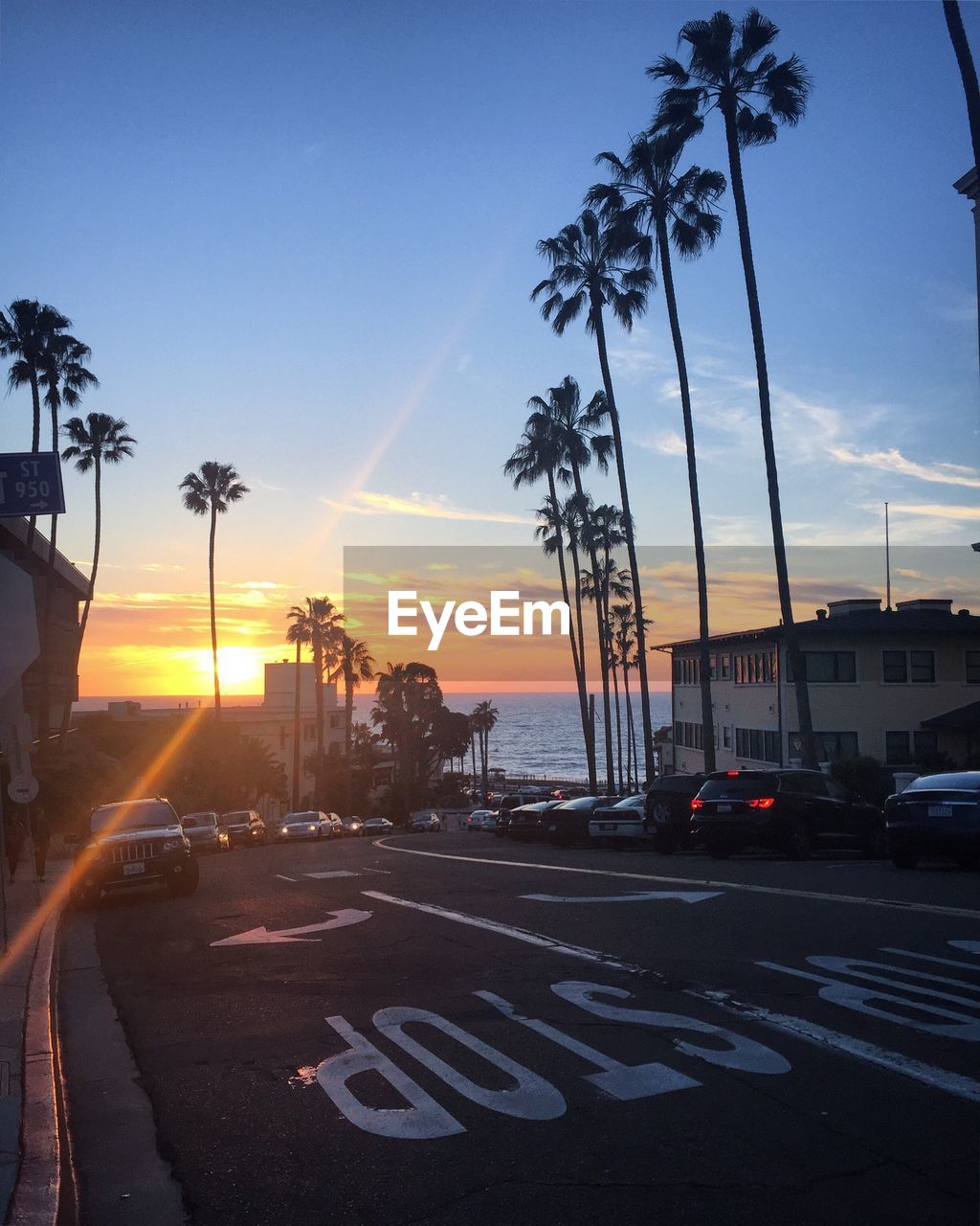 CARS ON ROAD AGAINST SKY DURING SUNSET