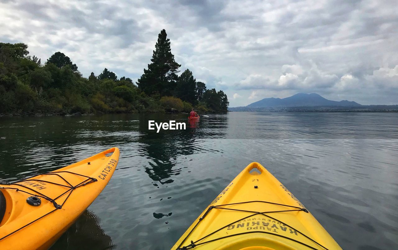 YELLOW FLOATING ON WATER AGAINST LAKE