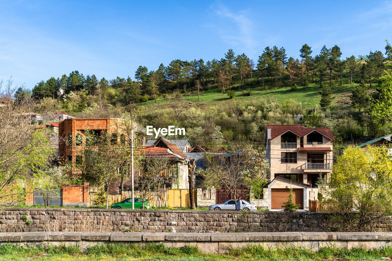 Residential home and buildings on getapnya street with hill and blue sky background