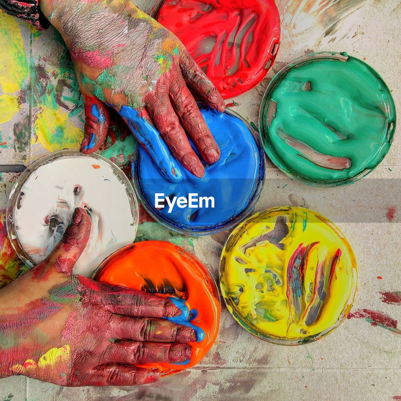 A child's hands mixing paints 