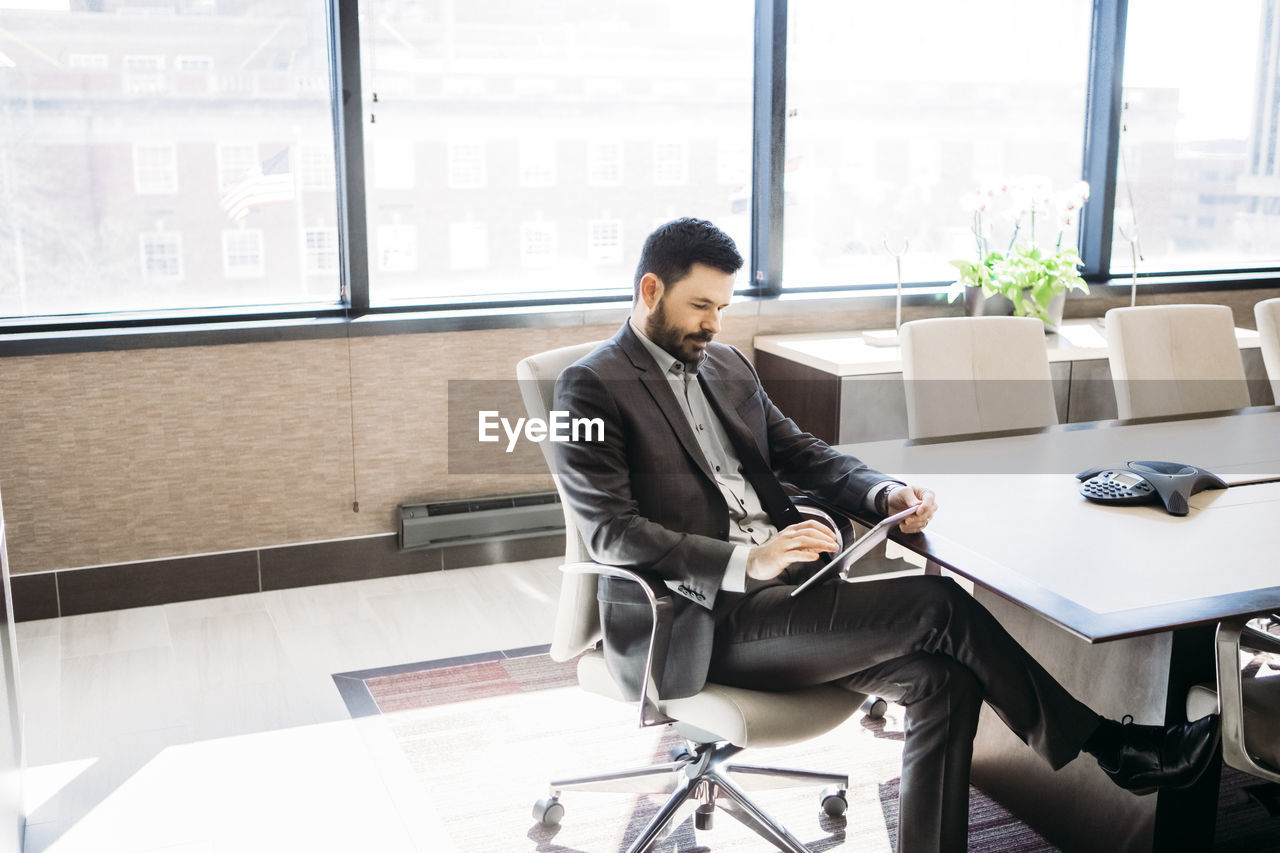 Businessman using tablet computer in board room at office