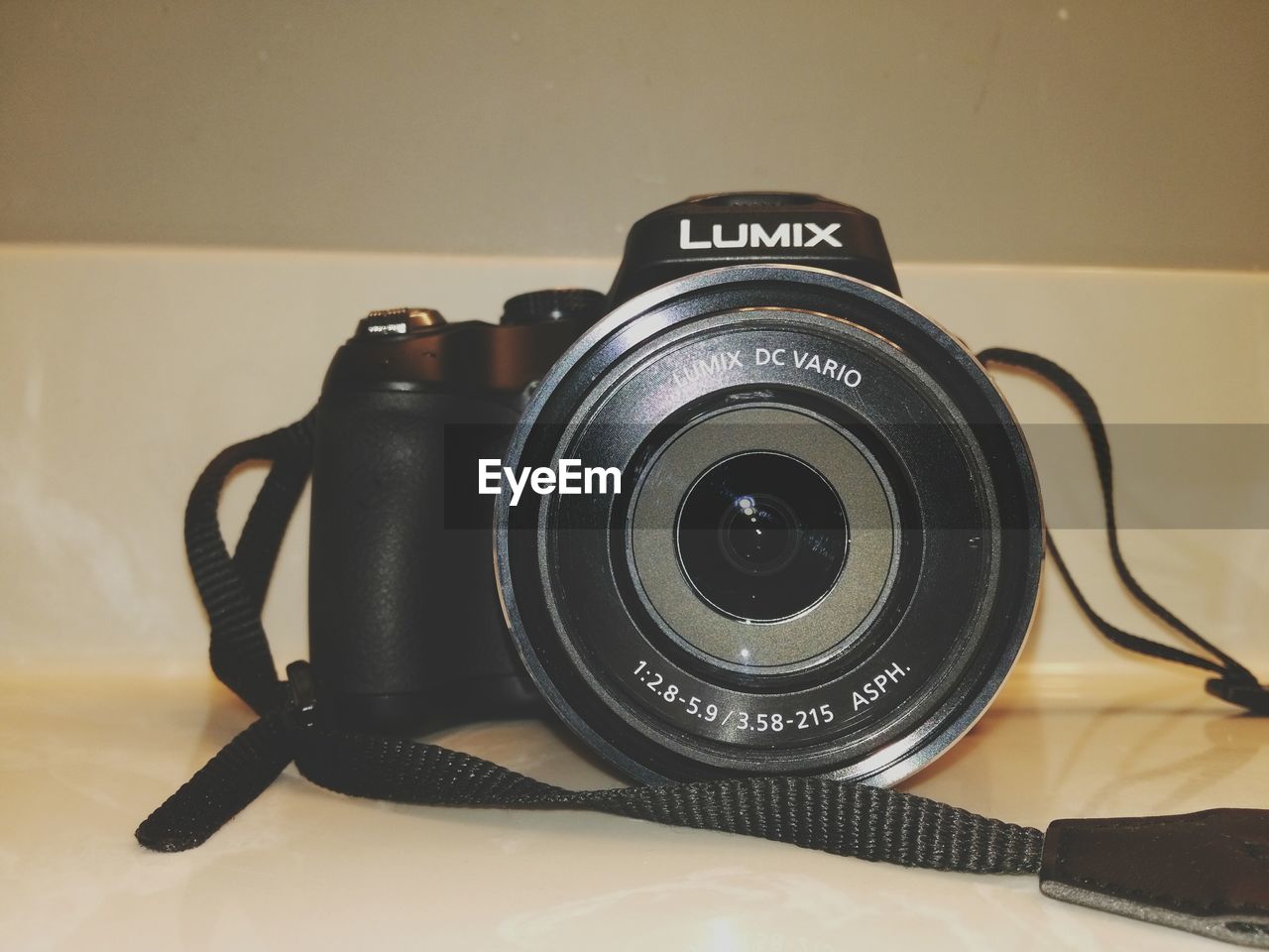 CLOSE-UP OF CAMERA ON TABLE AGAINST WALL