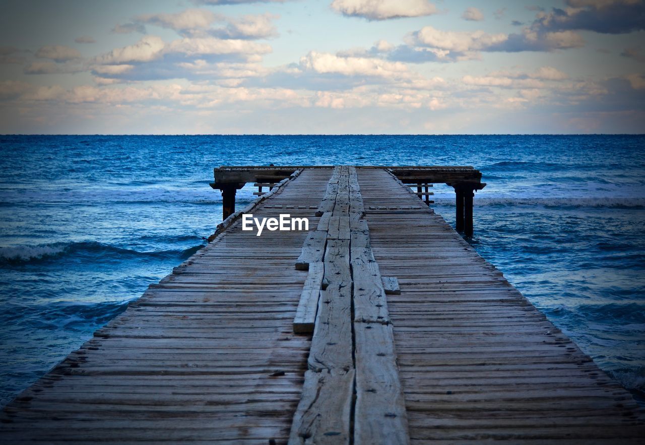 Wooden jetty leading to calm sea