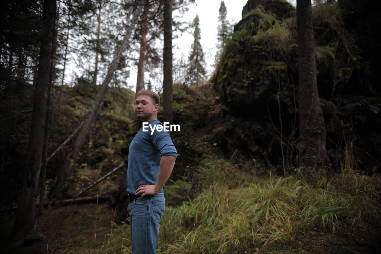 MAN LOOKING AT FOREST