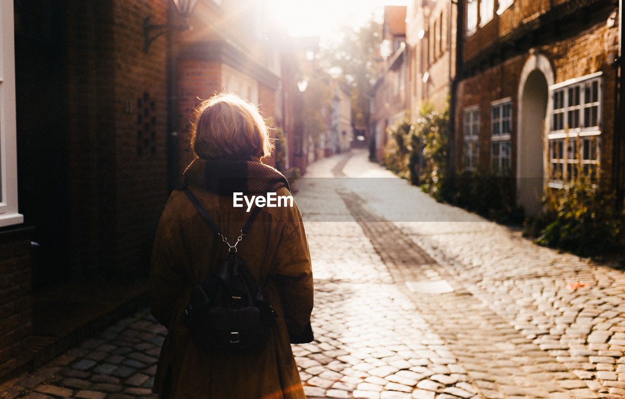 Rear view of woman walking on street in city